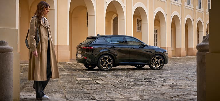 A passenger-side profile of a European version black 2025 Alfa Romeo Tonale Intensa.