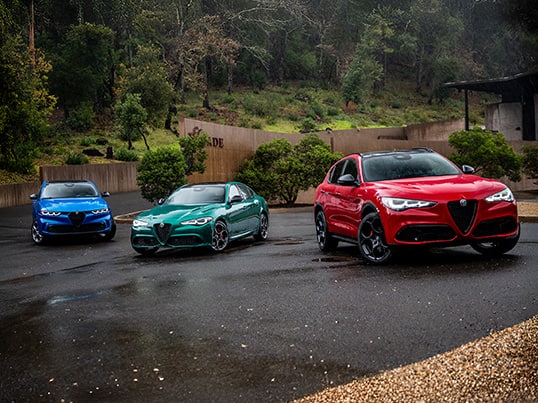 Grupo de tres modelos de Alfa Romeo 2026: de izquierda a derecha, un Tonale Sport Speciale azul, un Giulia Veloce verde y un Stelvio Veloce rojo.
