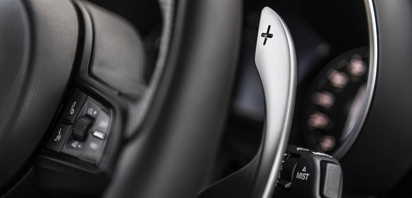 Display An extreme close-up of a paddle shifter on the steering wheel of the 2023 Alfa Romeo Giulia.