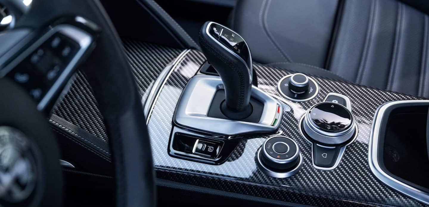 Display A close-up of the gear shifter and the center console of the 2023 Alfa Romeo Stelvio Quadrifoglio.