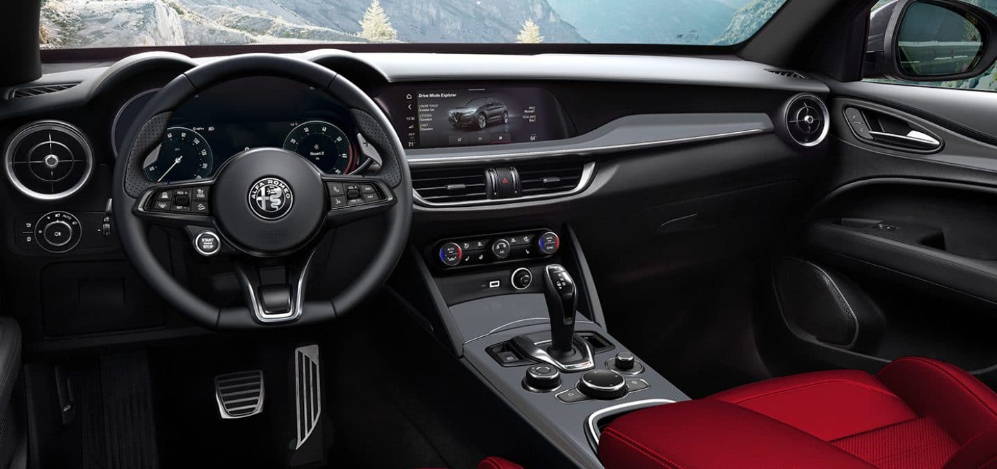 Display The interior of the 2024 Alfa Romeo Stelvio TBD focusing on the steering wheel, Driver Information Digital Cluster, center stack and multitouch display.