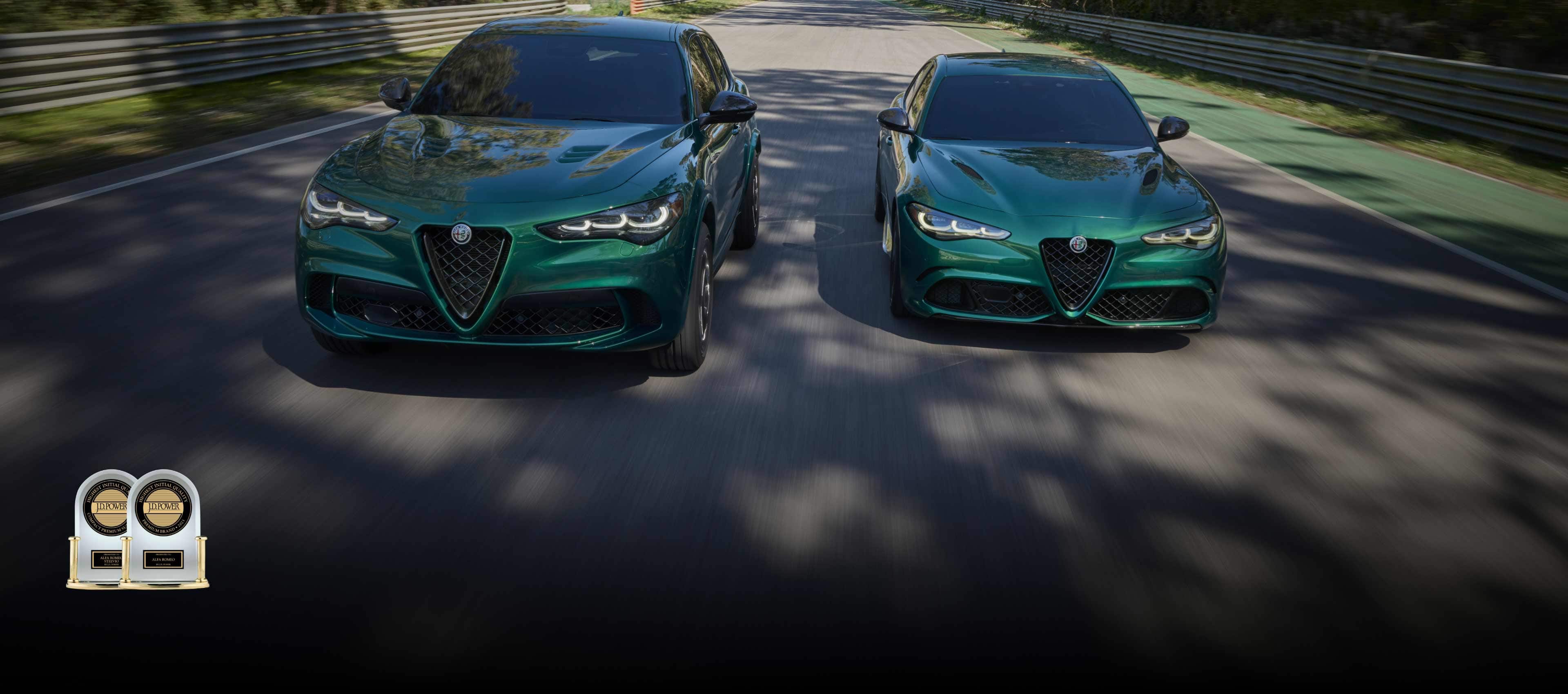 A green 2024 Alfa Romeo Stelvio Quadrifoglio on the left and a green 2024 Alfa Romeo Giulia Quadrifoglio on the right, being driven side-by-side. J.D. Power Highest Initial Quality Compact Premium SUV—2023 Presented to Alfa Romeo Stelvio by J.D. Power. J.D. Power Highest Initial Quality Premium Brand—2023 Presented to Alfa Romeo by J.D. Power.
