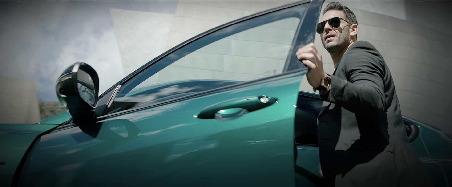 A man opening the driver’s door of a 2024 green Alfa Romeo Tonale.