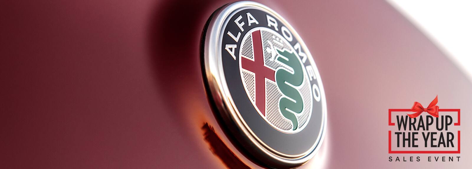 A close-up of the Alfa Romeo badge. Wrap Up The Year Sales Event logo.